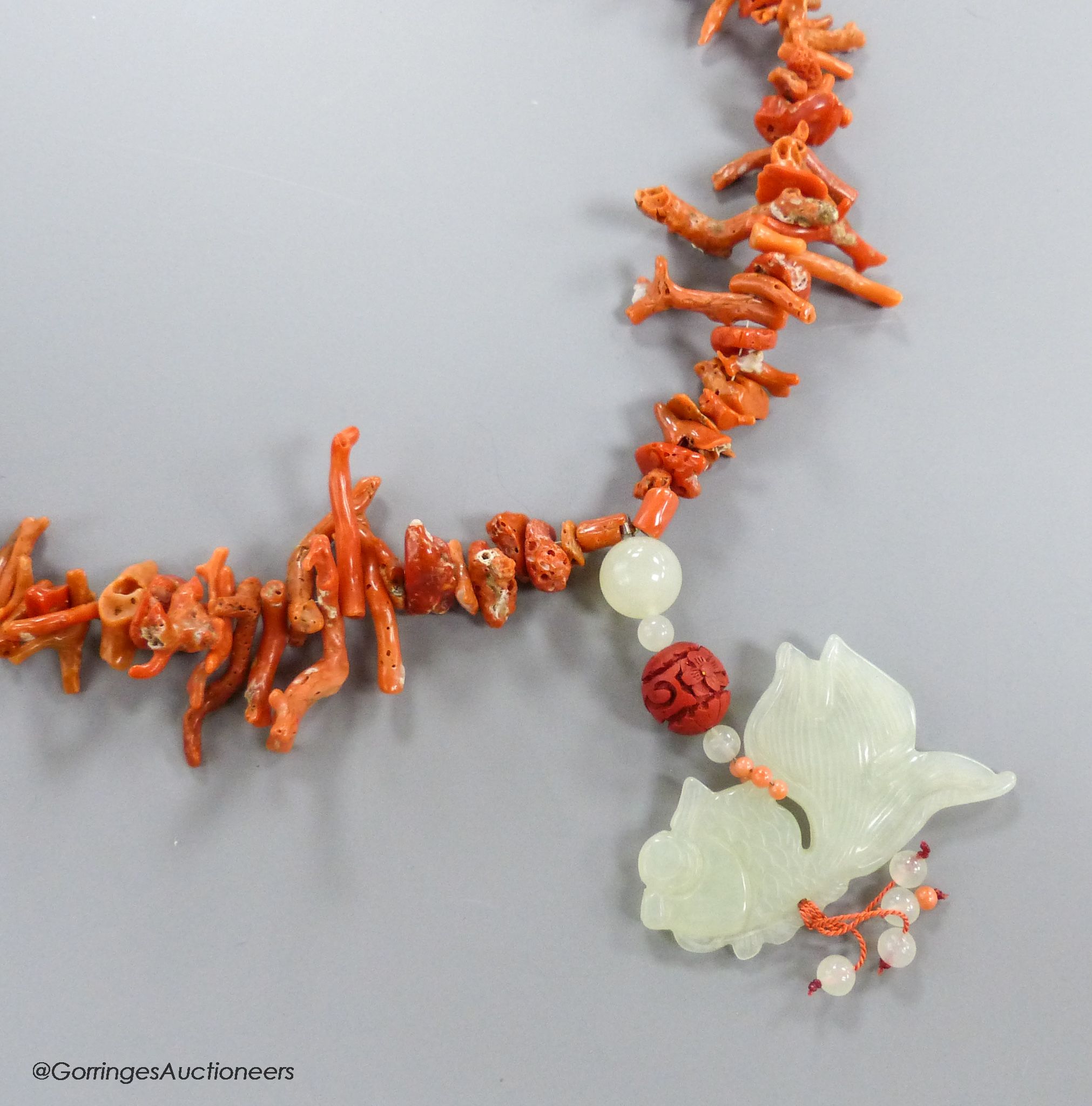 A jagged coral bead necklace, with jade pendant, carved as a fish, necklace approx. 88cm, fish length 66mm, gross weight 114 grams.